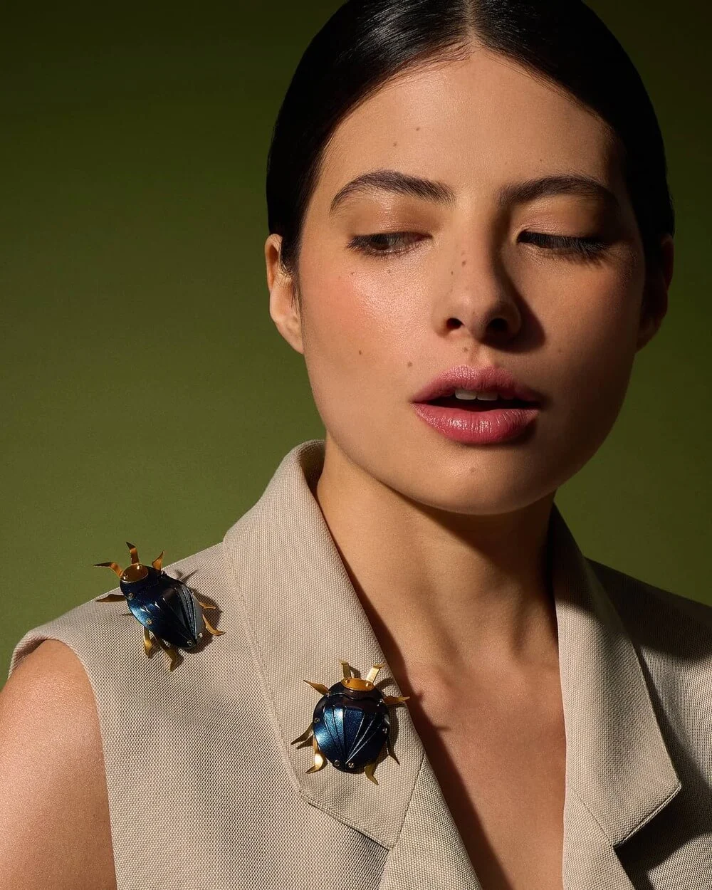 A woman in a blazer adorned with beetle-shaped pins